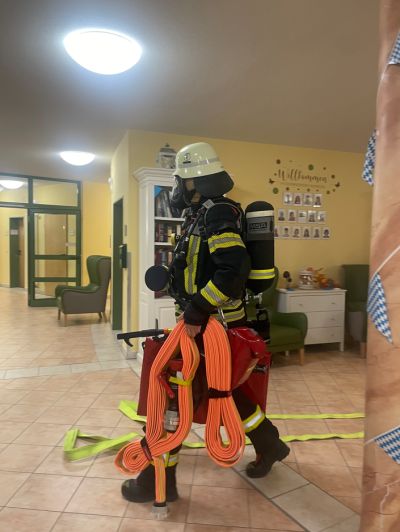 Feuerwehrmitglied mit Schläuche